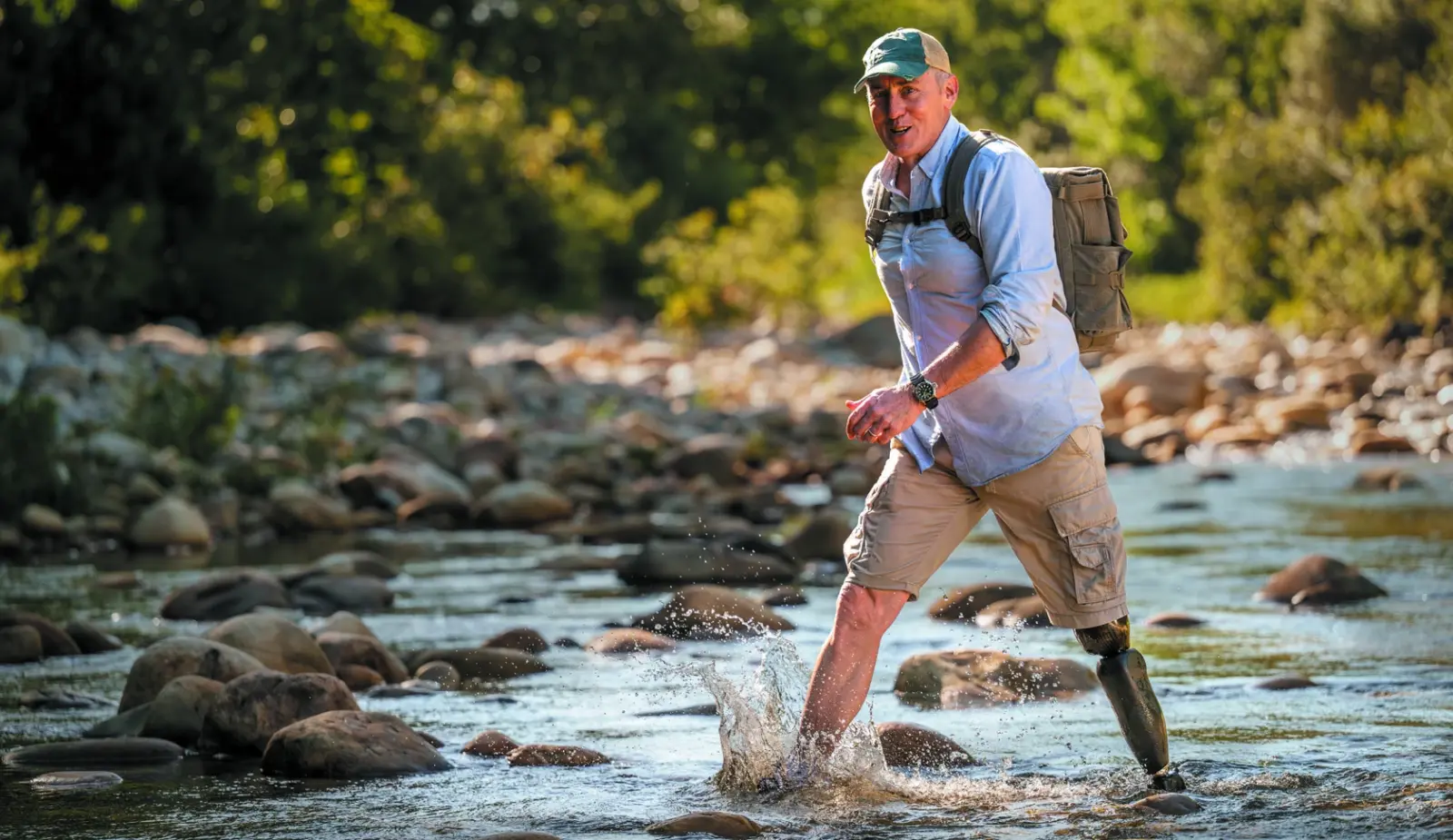 Homme amputé de la jambe marchant dans une rivière avec sa prothèse tibiale